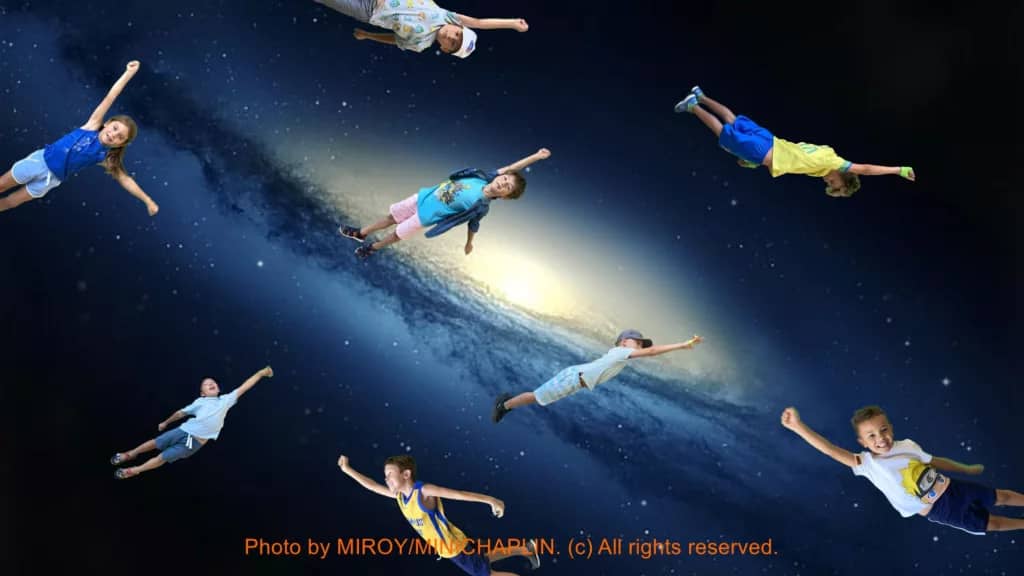 Imagen de niños y niñas volando sobre un fondo con la imagen del universo. Recorte de croma.